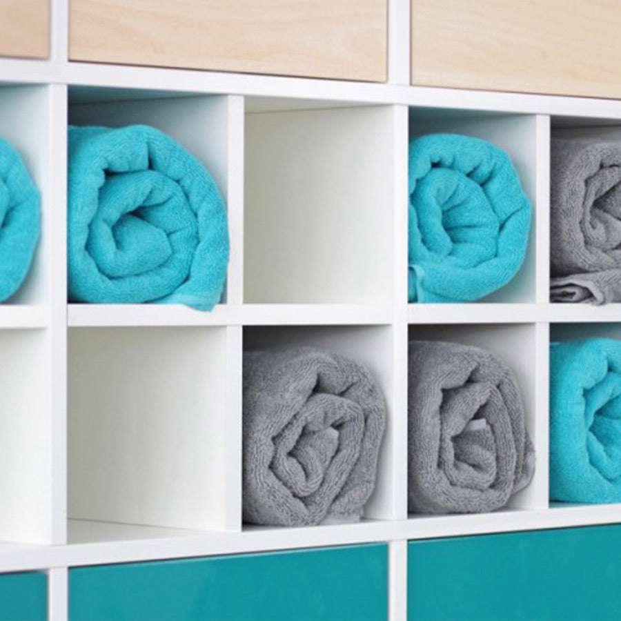 Regaleinsatz: macht aus 1 Fach 4 Bereiche. Fächer sind mit gerollten Handtüchern befüllt.
