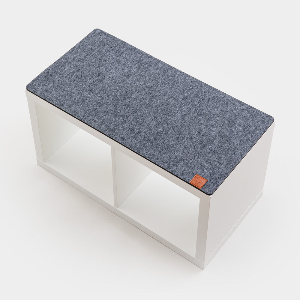 Kallax Bankauflage aus grauem Filz auf einem weißen IKEA Kallax Regal mit 2 Regalfächern.