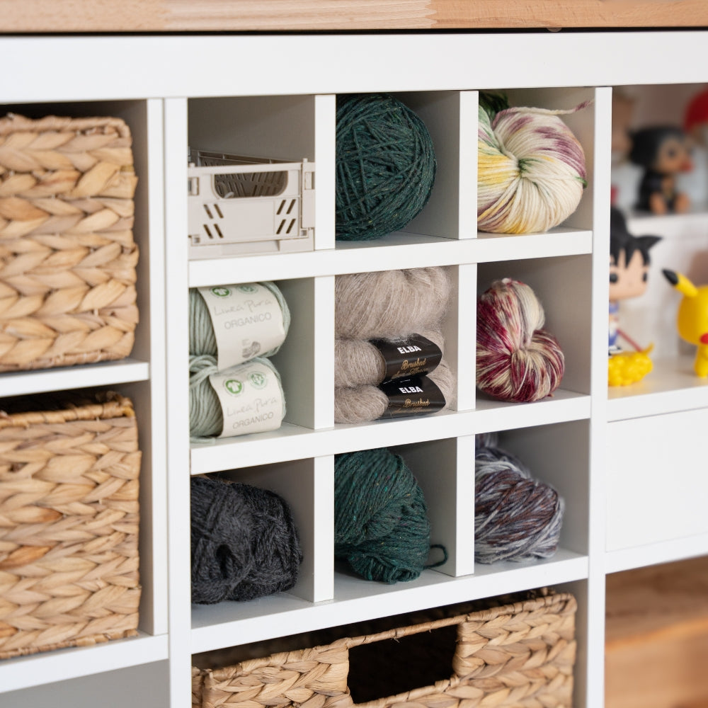 Detailaufnahme eines Kallax Regals im Wohnbereich. In dem Kallax Fach befindet sich ein passgenauer Fachteiler. Die dadurch entstehenden 9 kleineren Fächer werden hier zur Lagerung von Wolle genutzt.