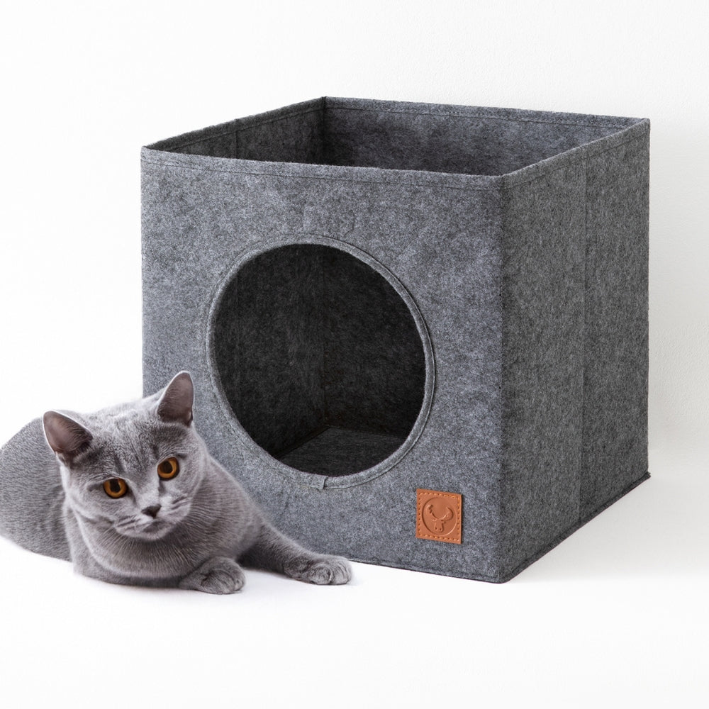 Grauer Kallax Katzenkorb aus Filz mit runder Öffnung und eine graue Katze.