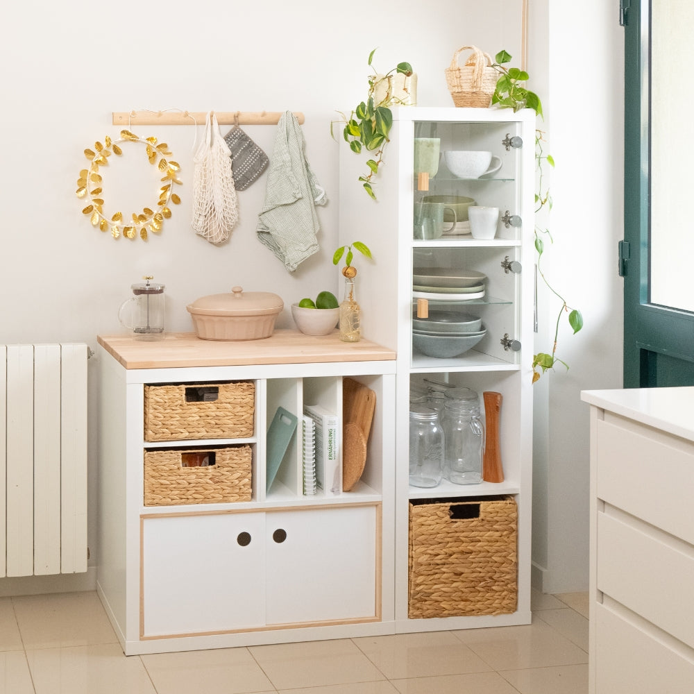 2 Kallax Regale sind in eine Küche umfunktioniert. Sie sind mit Körben und verschiedenen Einsätzen ausgestattet.