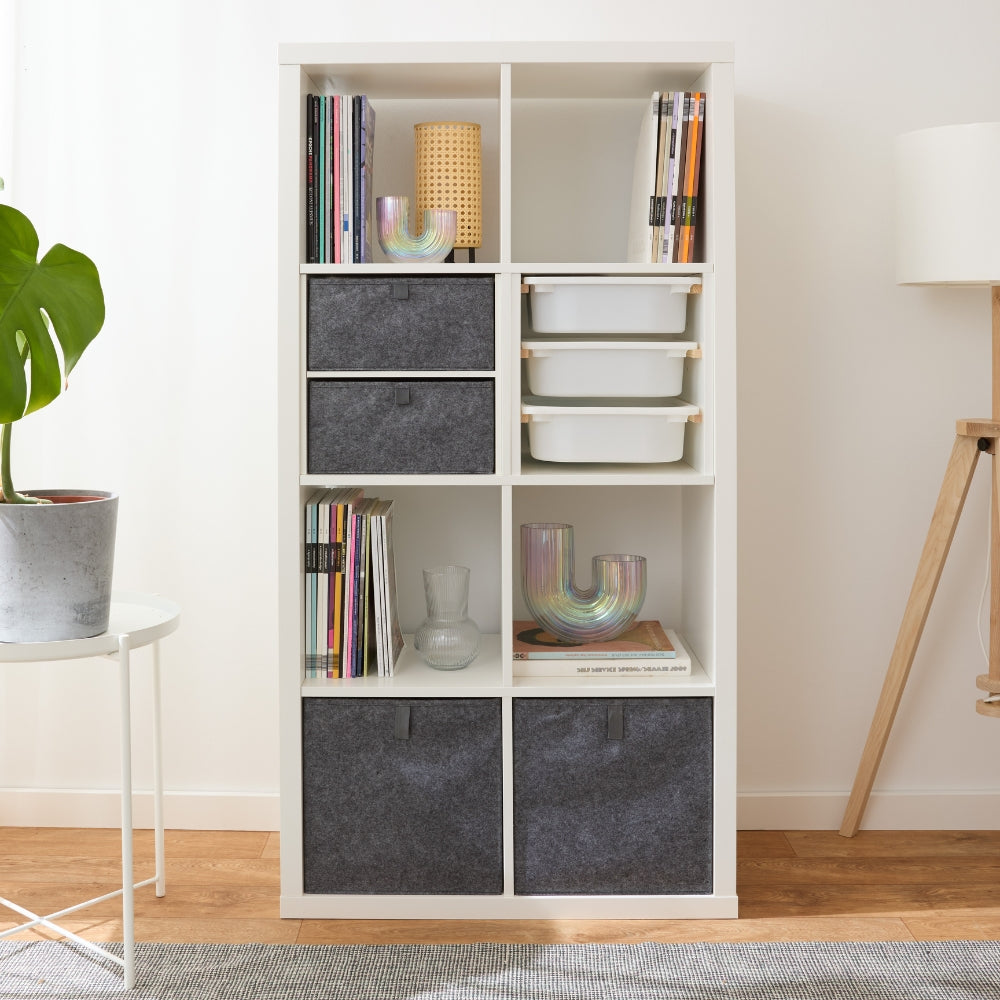 Weißes IKEA Kallax Regal mit 8 Fächern, graue Kallax Boxen aus Filz mit Ziehlasche und Trofastboxen.