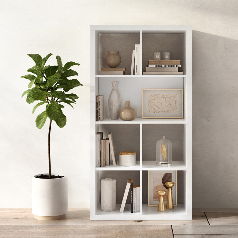 Beispielbild eines 2x4 Kallax Regals mit Deko und einer großen Pflanze. 2 Fächer sind mit einer weißen Rückwand zusammengeschlossen.