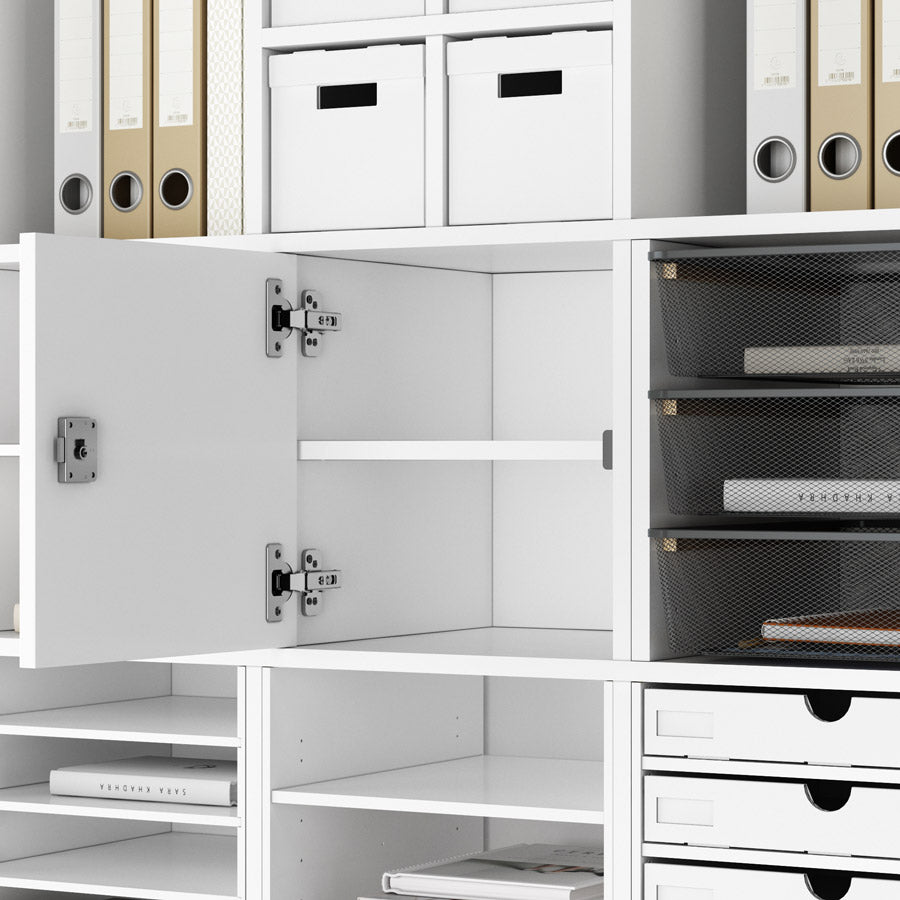 IKEA Kallax Regal als Büroeinrichtung: In der Mitte befindet sich ein Regaleinsatz mit einer Tür. Diese enthält ein zylinderschloss und ist abschließbar. Innen befindet sich ein Fachboden.