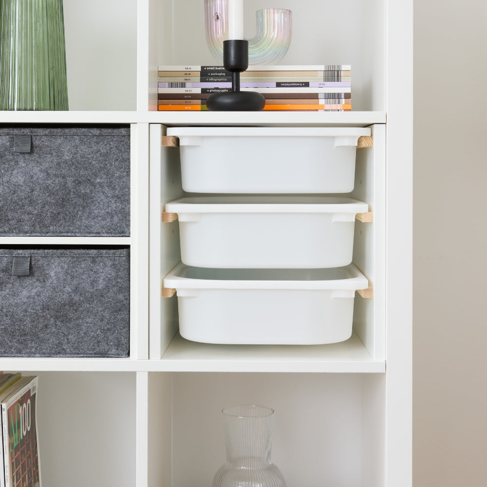 Passgenauer Einsatz in einem weißen Kallax Regal von IKEA, in den 3 weiße Kunststoffboxen eingeschoben sind.