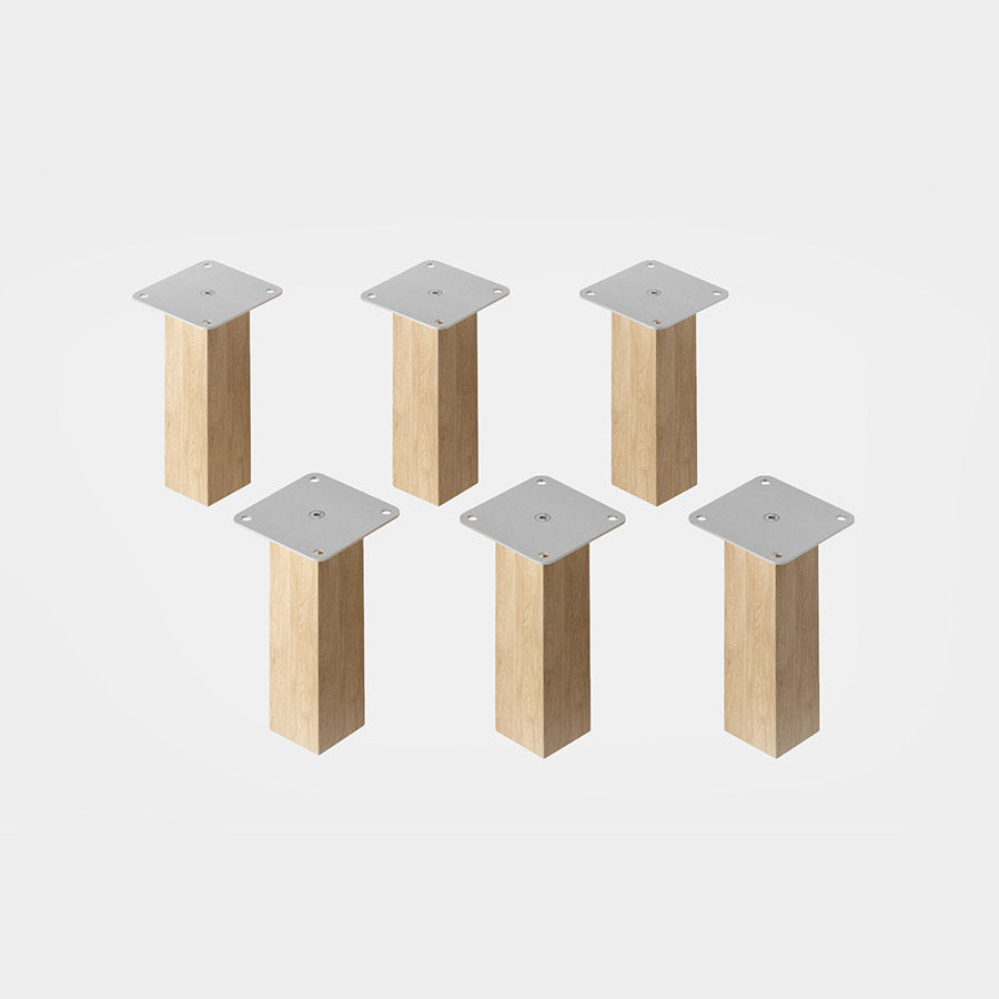 6-er Set Schrankfüße aus hellem Buchenholz. Sie sind quadratisch geformt und 16 cm hoch.