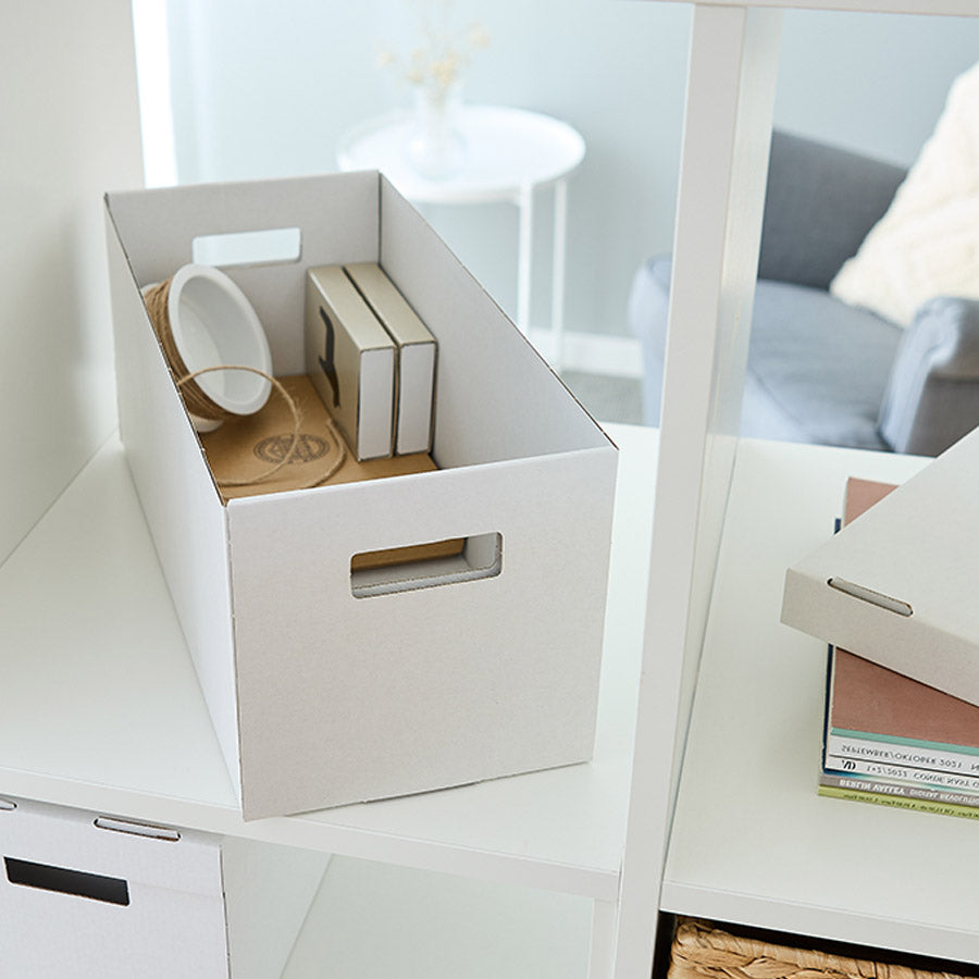 Weiße Faltbox im Kallax Regal, gefüllt mit Büromaterial und Bastelsachen.